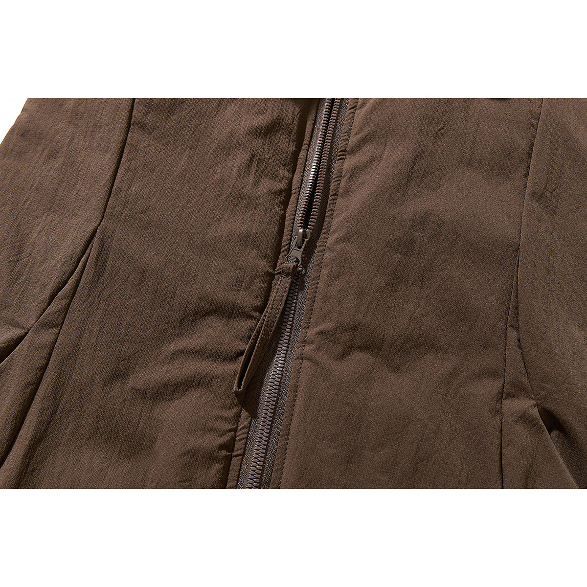 Close-up of the dark brown vest's front zipper, pull tab, and stitched panels.