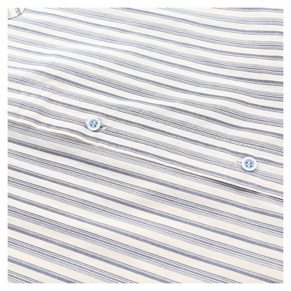 Close-up of two pale blue buttons on the placket of a cream shirt with blue-gray stripes.