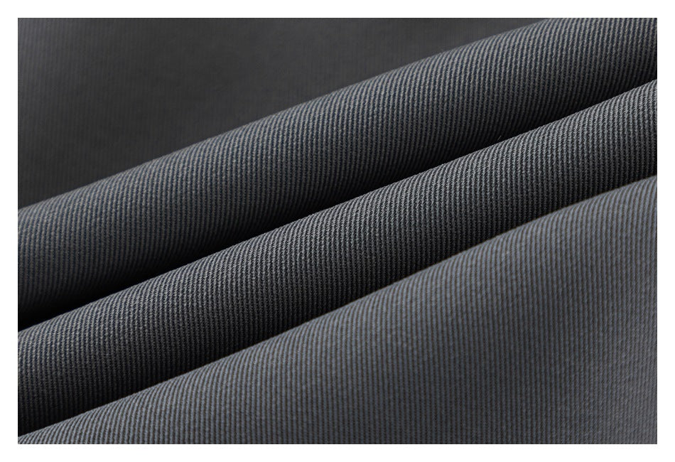 Close-up of dark gray and black fabric folded in diagonal layers, showing a fine ribbed texture.