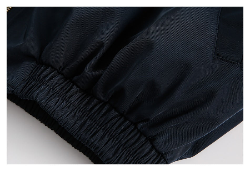 Close-up of the gathered elastic waistband and slanted pocket on a dark navy garment.