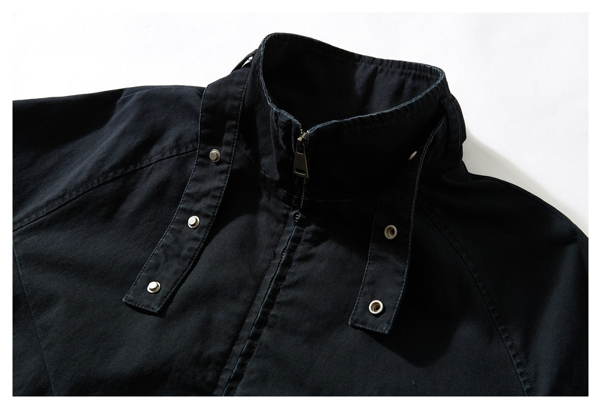 Close-up of a black jacket with its raised collar open and snap-fastening collar tabs visible.