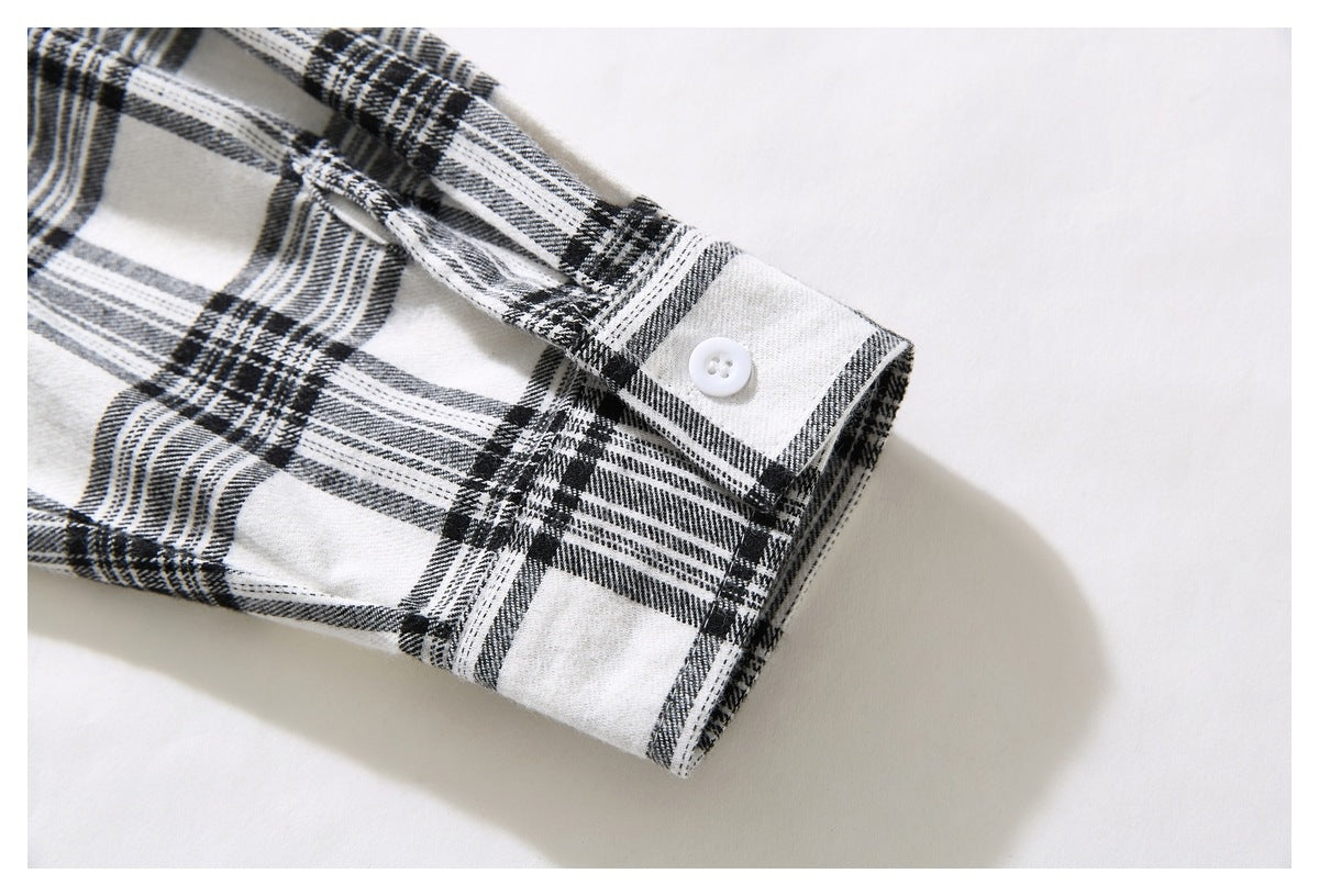 Close-up of the black-and-white plaid shirt cuff with a white button.