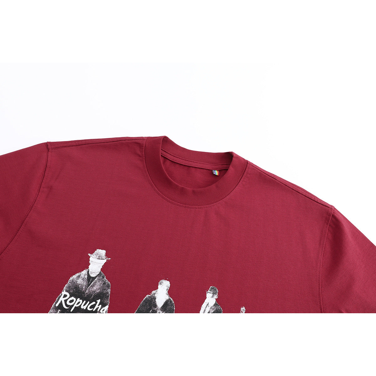 Close-up of a burgundy crew-neck T-shirt showing part of its monochrome figure print.