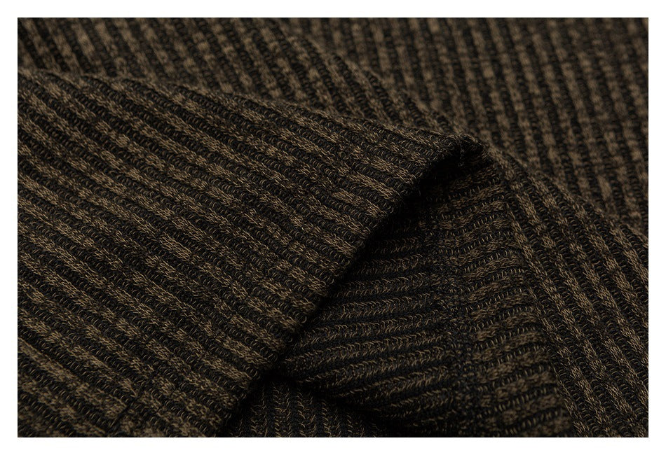 Close-up of dark marled knit fabric with narrow ribbed lines and a folded edge.