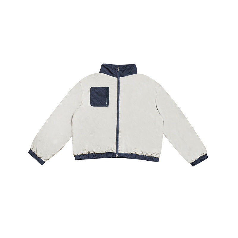 Front view of a pale jacket with a navy stand collar, center zipper, chest pocket, cuffs, and hem.