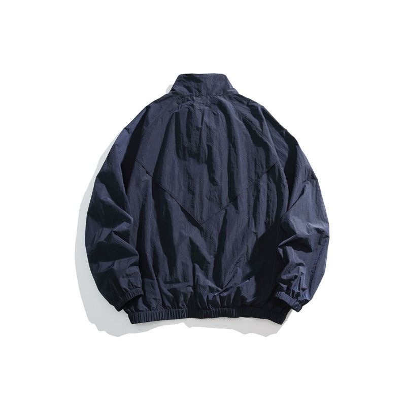 Back view of a dark navy zip-up jacket with a high collar, gathered cuffs and elastic hem.