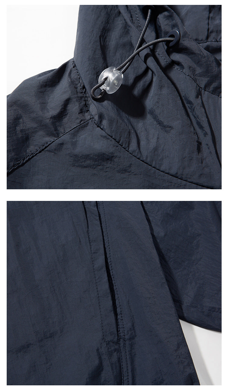 Close-up of the navy jacket's hood drawcord, cord lock, and shoulder seam, with another seam detail below.