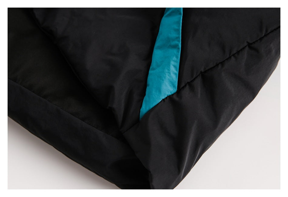 Close-up of a turquoise panel set into a seam on a black padded garment.
