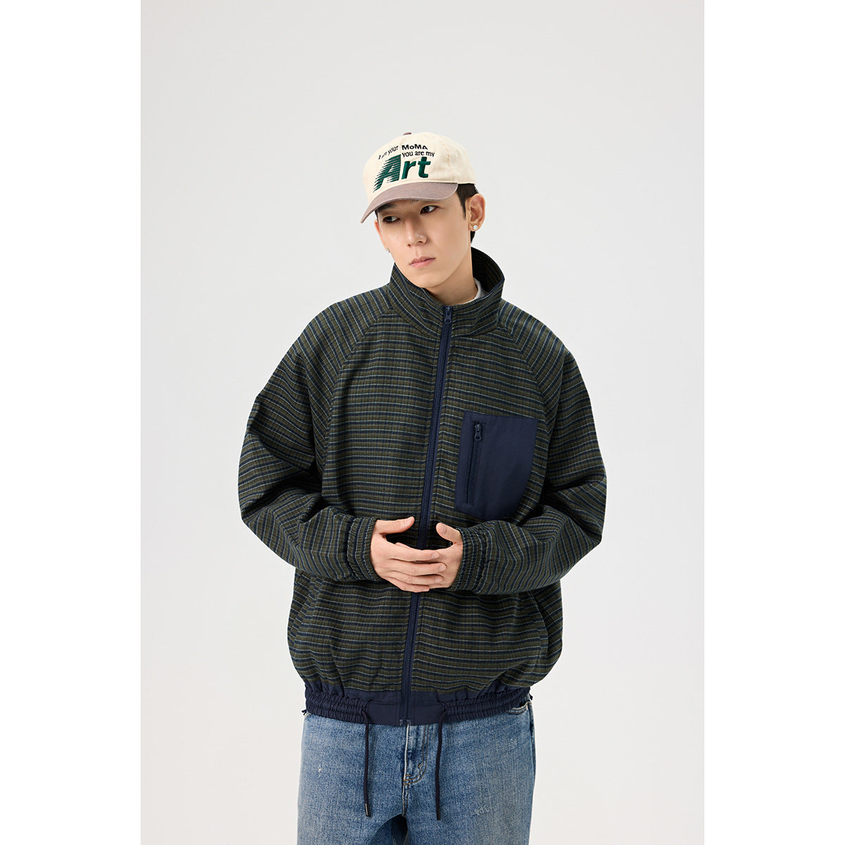 Model wearing a dark striped zip jacket with a stand collar, navy zip chest pocket and elastic hem.