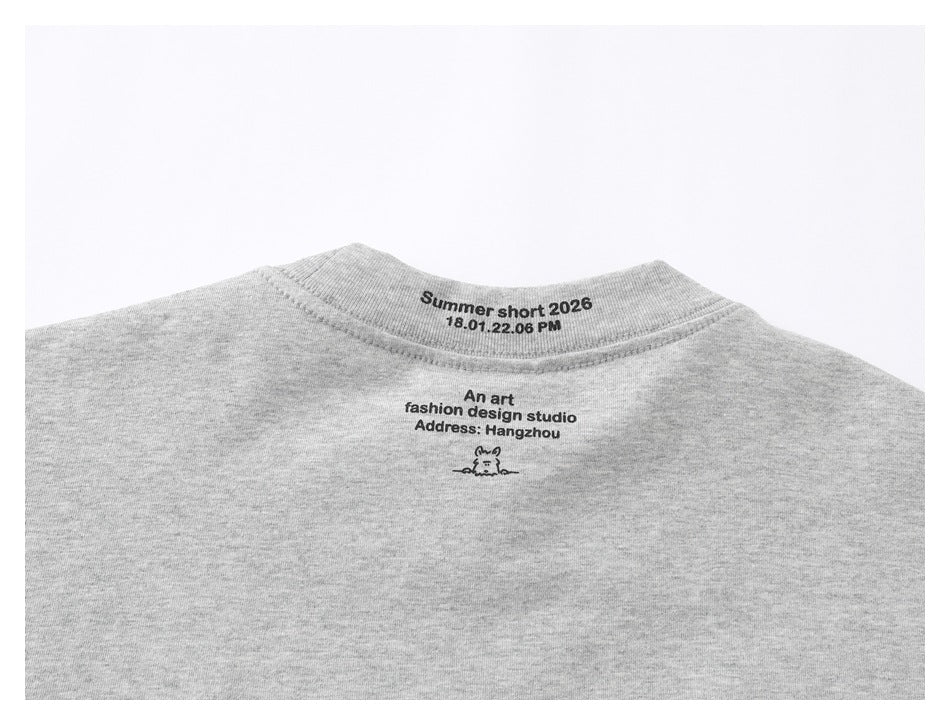 Upper back of a light gray T-shirt with black text printed below the crew neckline.