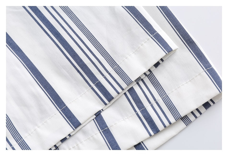 Close-up of the white shirt's navy stripe pattern and stitched hem.