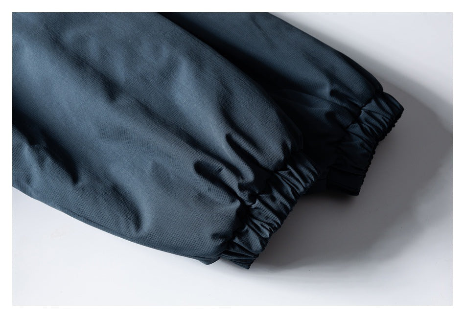 Close-up of two dark navy jacket sleeves with gathered elastic cuffs.