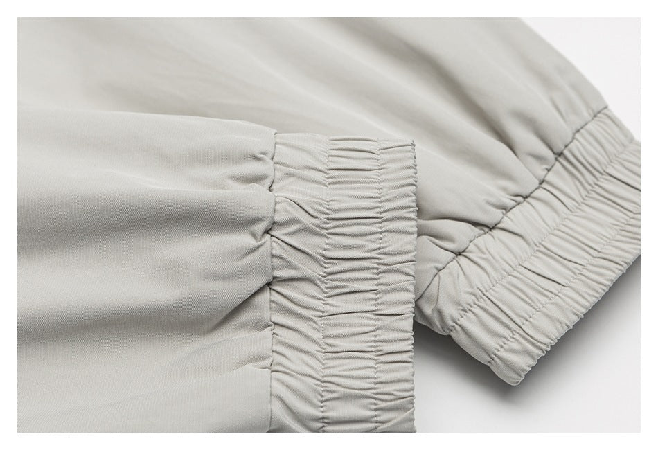Close-up of gathered elastic edging on light gray fabric.