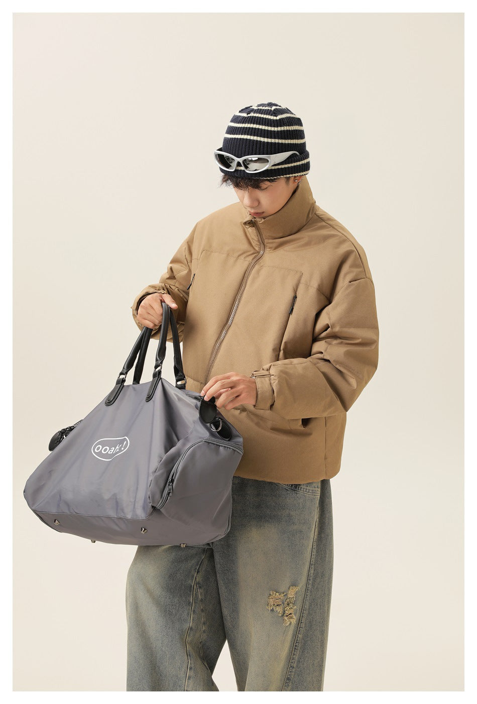 Closer view of a model in a tan puffer jacket with a zipped high collar and roomy pockets.