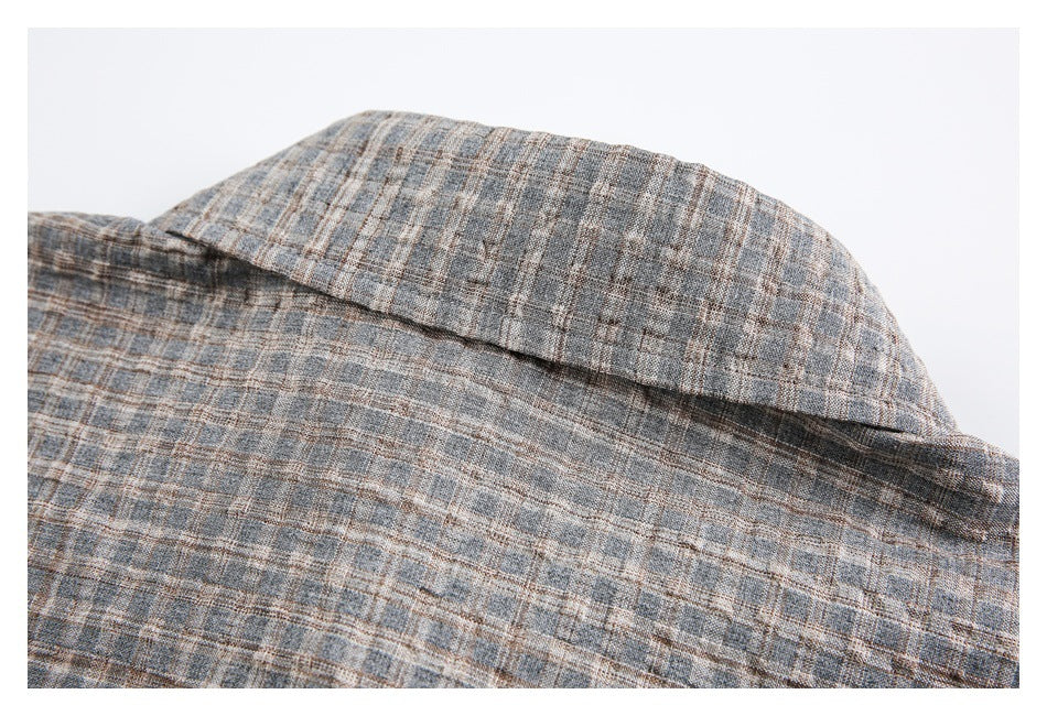 Close-up of the plaid shirt's folded collar and upper back seam.