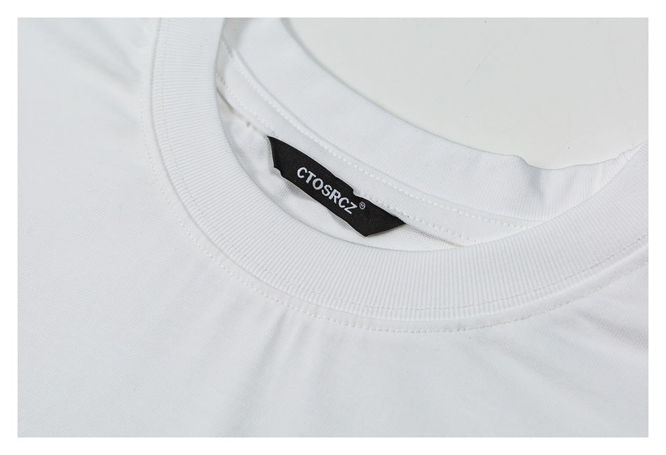 Close-up of a white crew neckline with a black sewn-in label bearing white lettering.