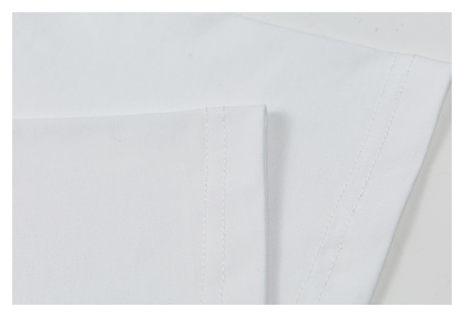 Close-up of plain white garment fabric showing overlapping panels and stitched seams.