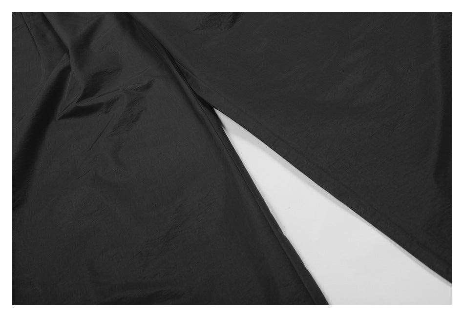 Close-up of the black pants' wide legs and inner seam.