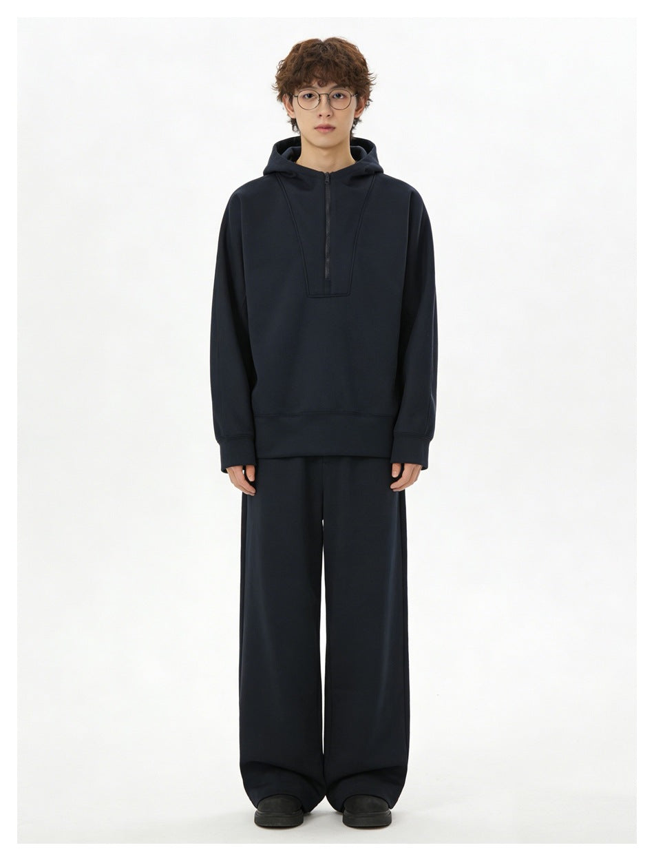 Model wearing navy half-zip hoodie with matching wide-leg pants and black shoes, full-length front view