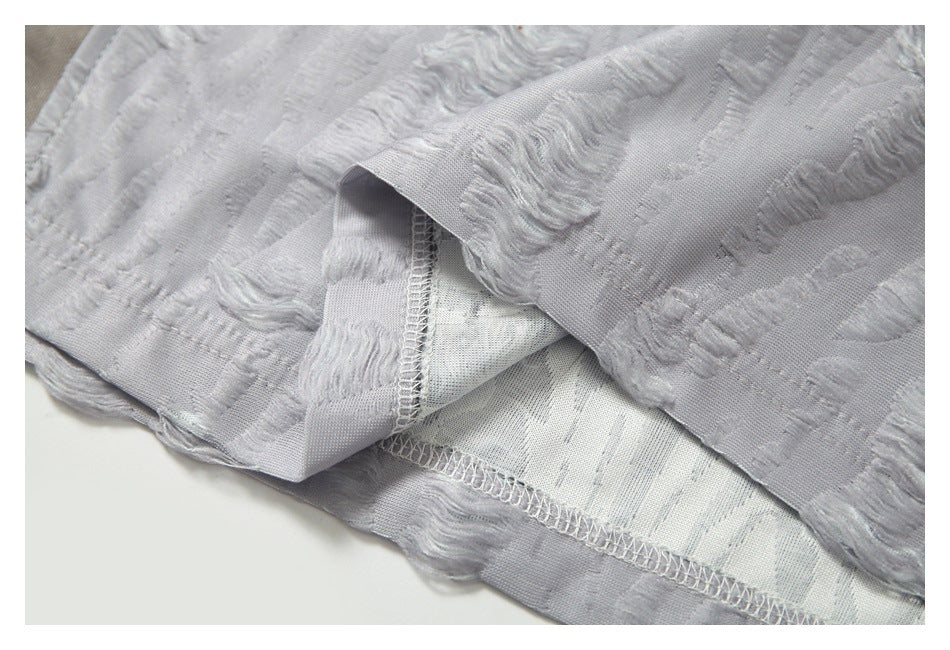 Close-up of the garment's folded edge, inner side, and overlocked seam.