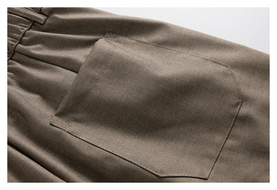 Close-up of a taupe-brown garment with a large stitched patch pocket.