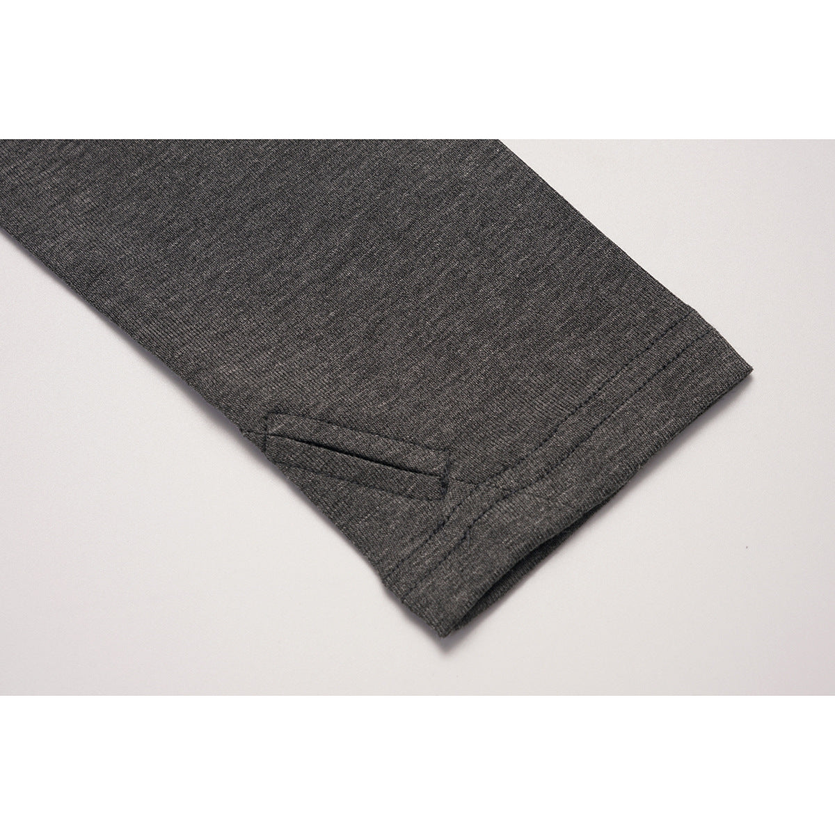 Close-up of a charcoal gray sleeve cuff with double stitching and a small slit detail.