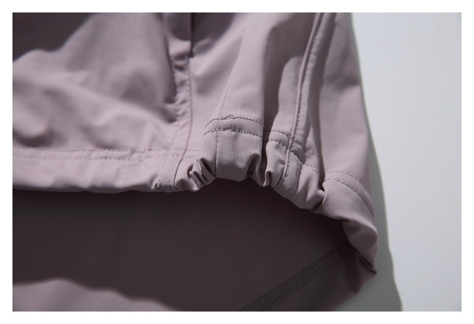 Close-up of a muted mauve garment showing gathered, stitched edge detailing.