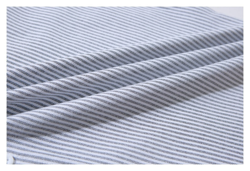 Close-up of fine gray stripes across softly folded white shirt fabric.