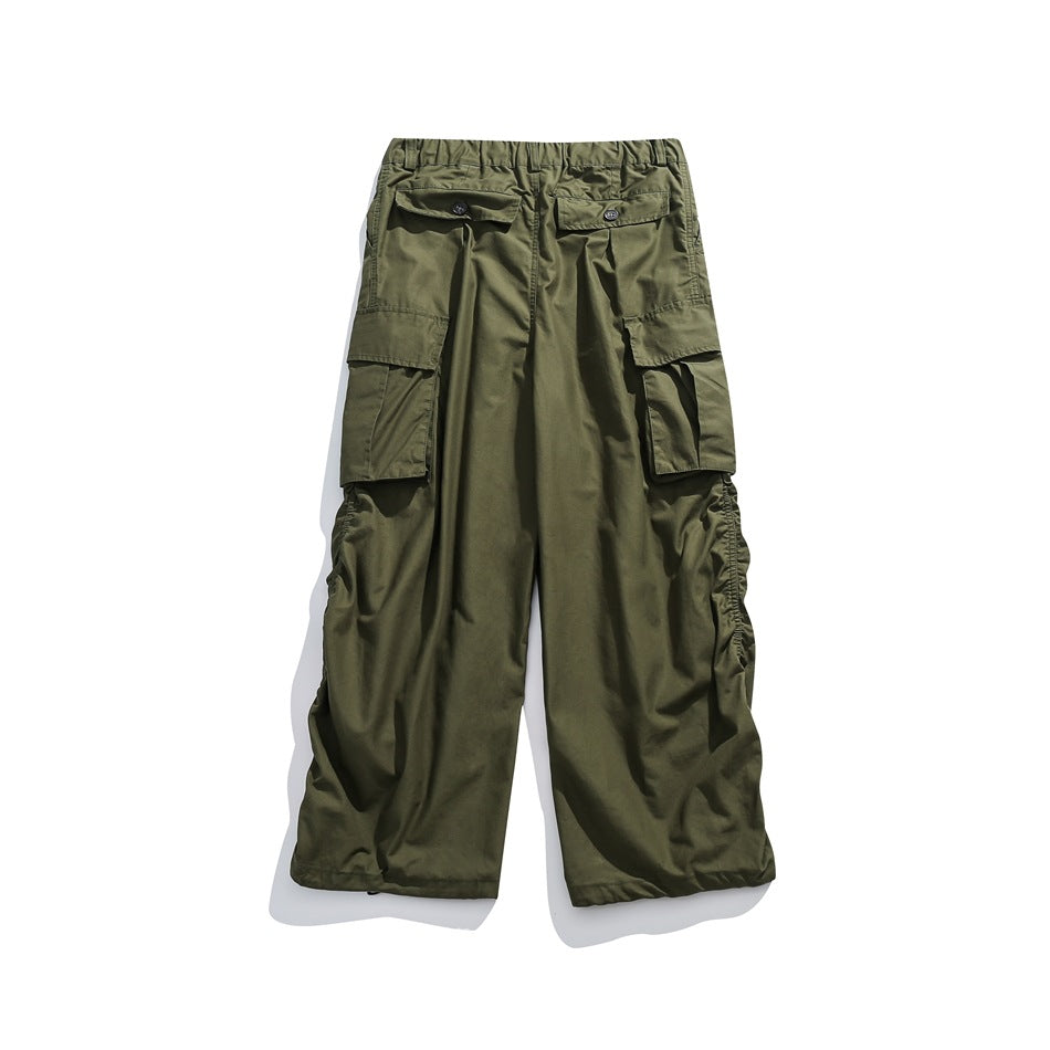 Back view of olive green cargo pants with button-flap rear pockets, large side pockets, and gathered hems.