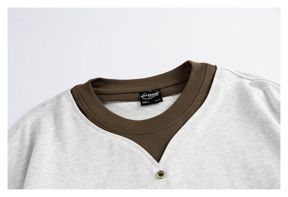 Partial front view of a light gray shirt with a dark brown ribbed neckline and a single button.