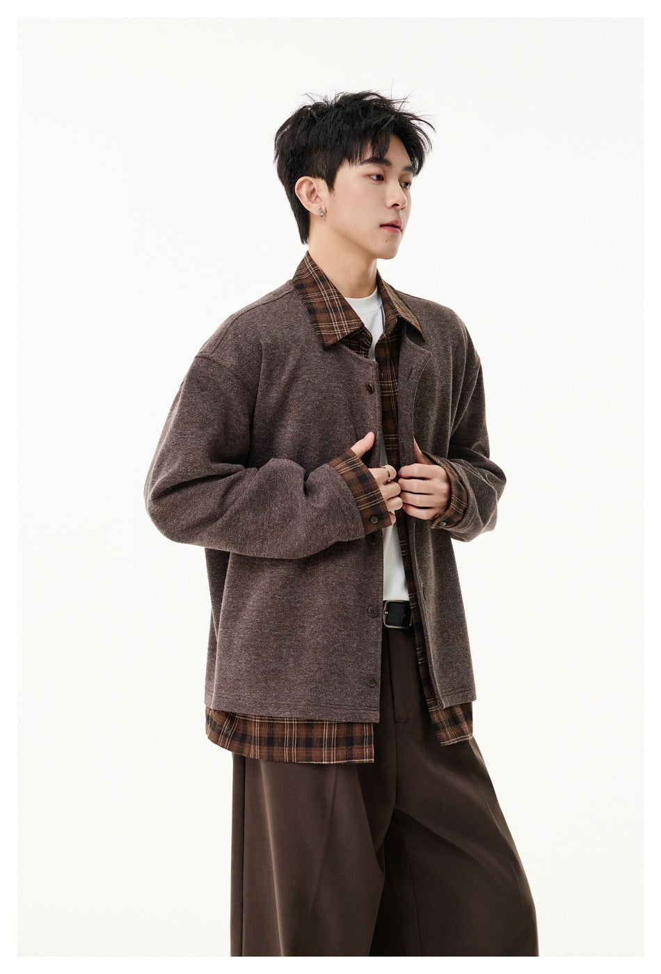 Model wearing a muted brown button-front jacket over a brown plaid shirt and dark brown trousers.