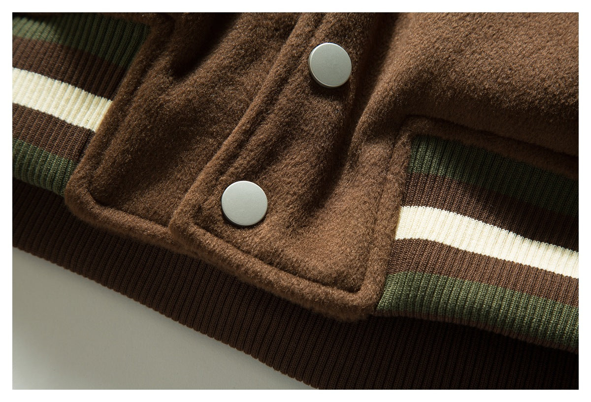 Close-up of the brown jacket hem, silver snap buttons, and striped dark green, cream, and brown ribbing.