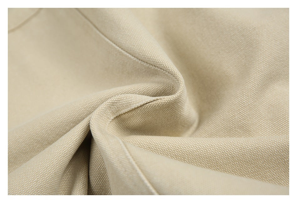 Close-up of the beige jacket's woven outer fabric, folded to show its texture.
