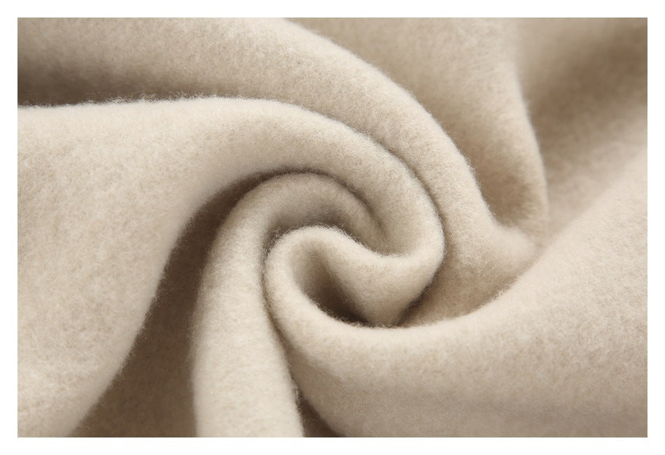 Close-up of fuzzy beige fabric curled into a spiral to show its surface texture.