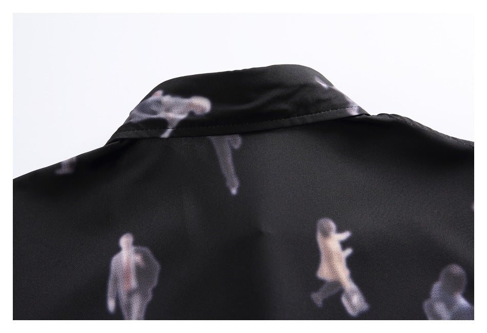 Close-up of a black garment's collar and back, printed with small blurred figures in pale tones.