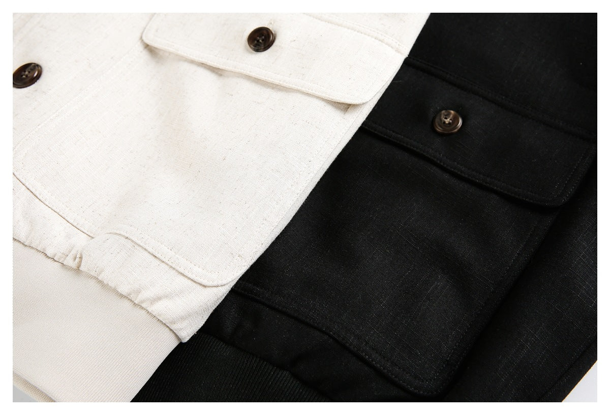 Close-up of cream and black jacket panels, showing buttoned flap pockets and ribbed hems.