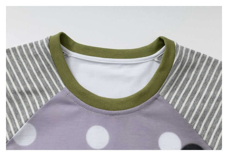 Close-up of an olive-green crew neckline and gray striped raglan sleeves above a lavender polka-dot shirt front.