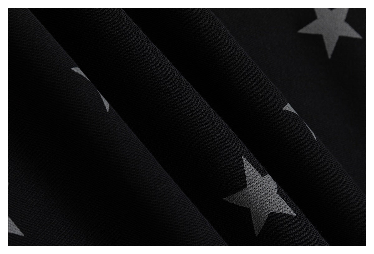 Close-up of black fabric printed with scattered gray stars.