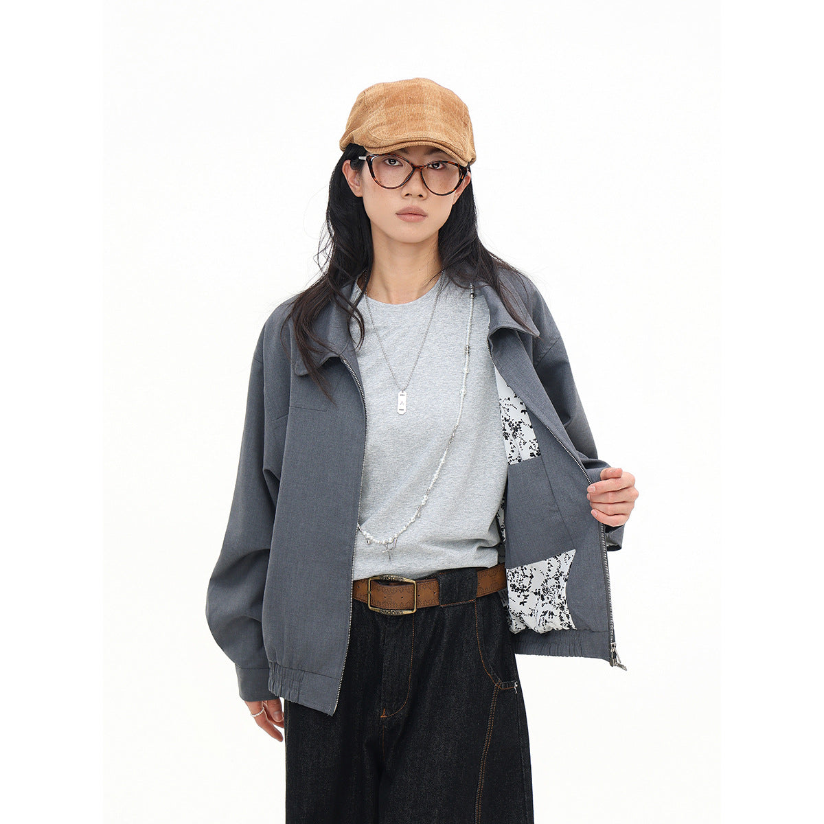 Model holds open a gray zip jacket to show its black-and-white patterned lining.