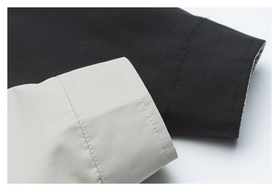 Close-up of a black jacket sleeve beside a light gray cuff, showing fabric texture and stitching.