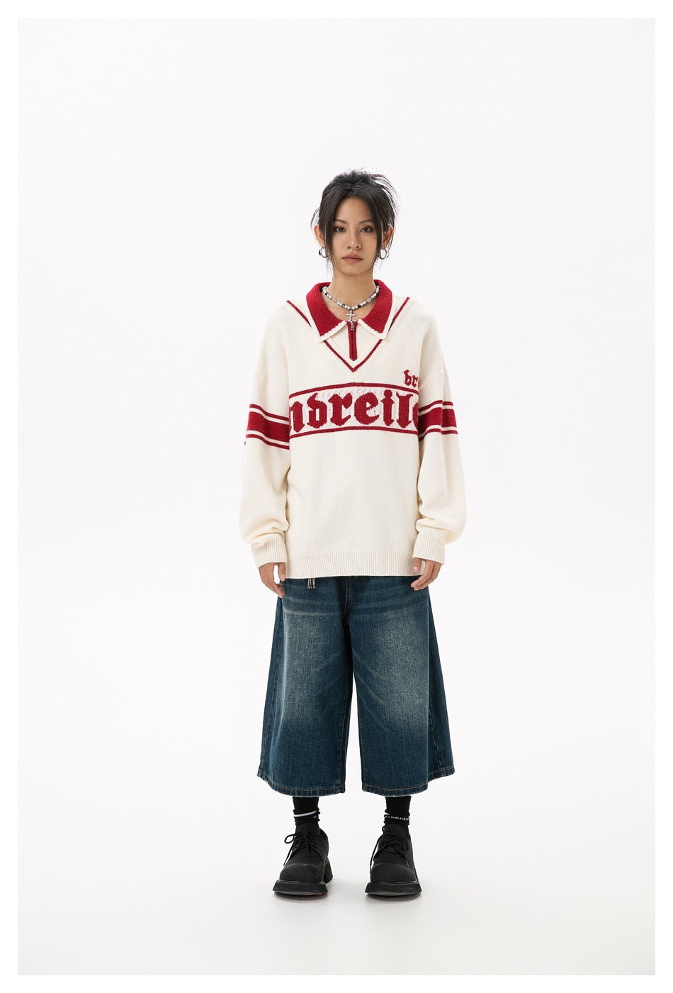 Model wearing the beige and red knit pullover with wide-leg denim shorts and black shoes, front view