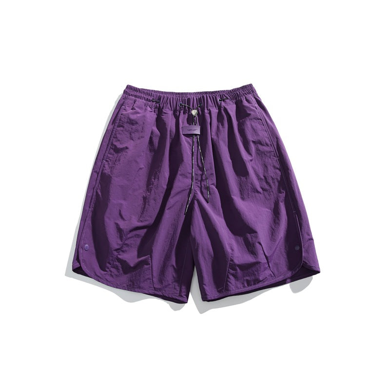 Purple knee-length shorts with elastic waist, drawcord with toggle and curved side hems, flat lay