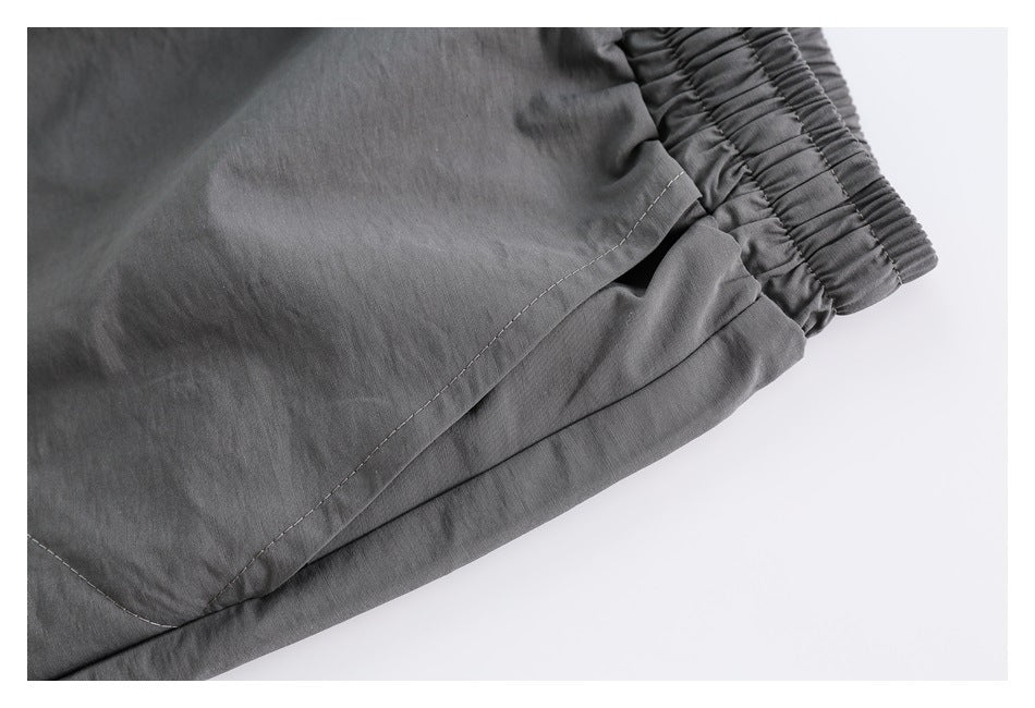 Close-up of gray bottoms showing the elastic waistband, side seam, and pocket opening.