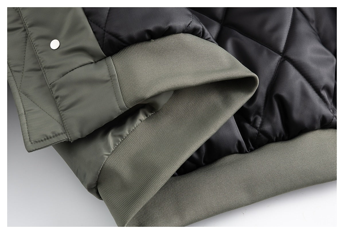 Close-up of an olive-gray jacket with a ribbed cuff, snap fastening, and black quilted lining.