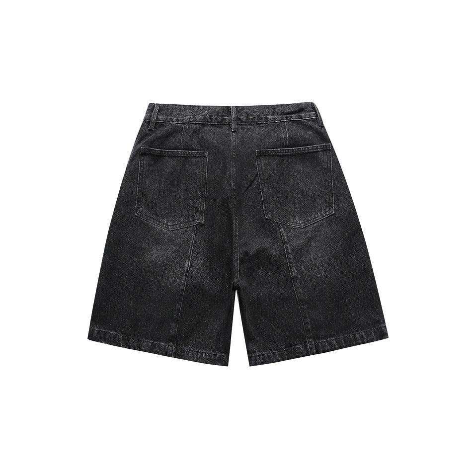 Back view of washed black denim shorts with two patch pockets and vertical seams, flat lay on white