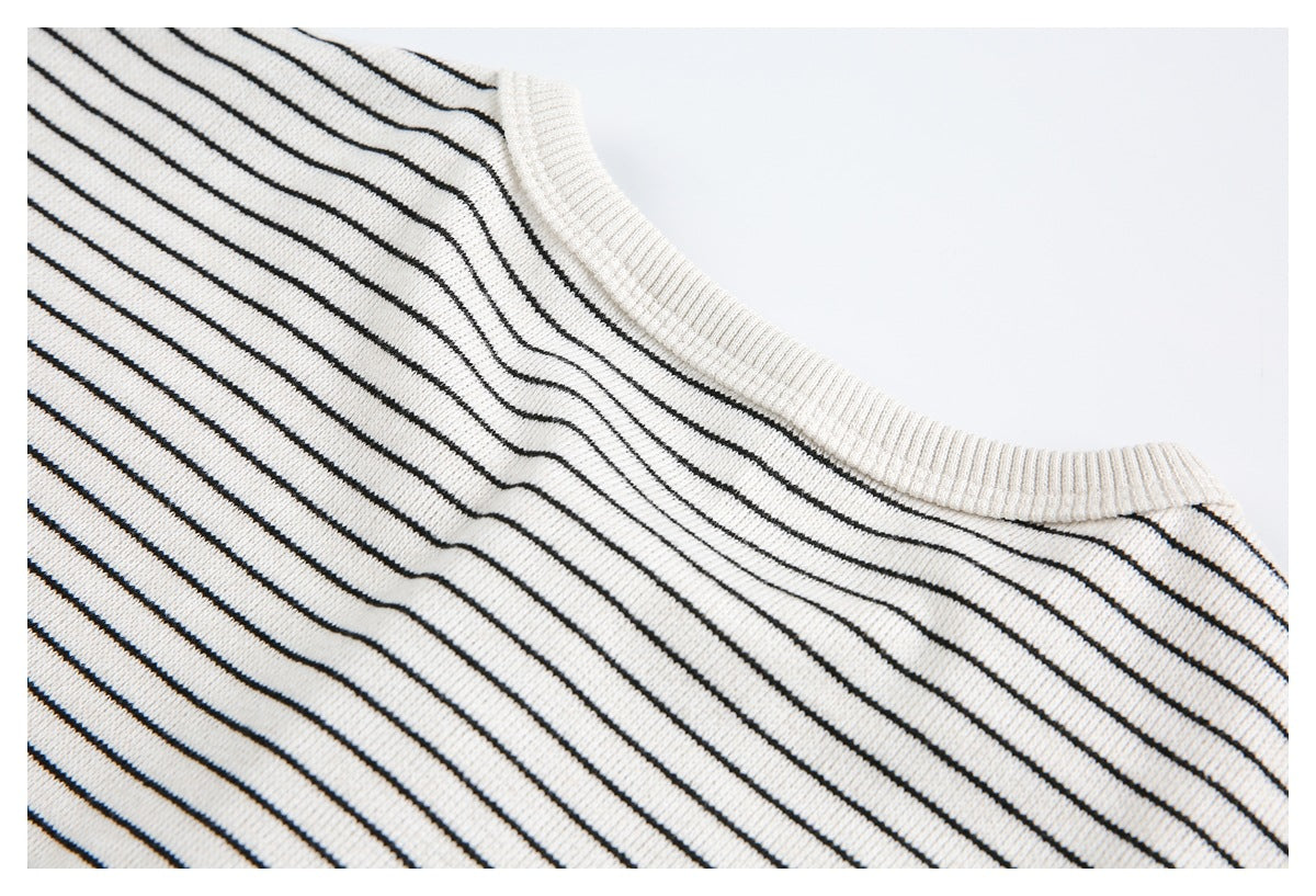 Close-up of the cream ribbed crew neckline on a knit top with thin black stripes.