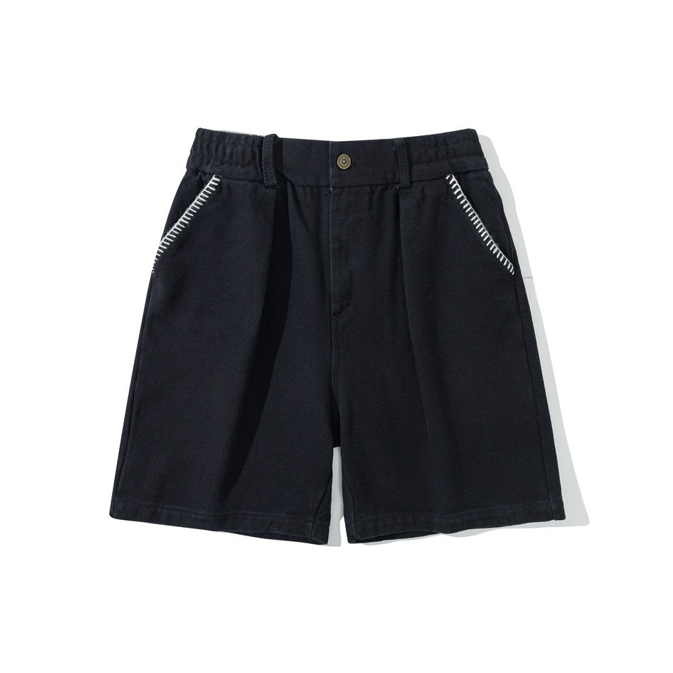 Black knee-length shorts with elastic waist, front button, pleats and white contrast stitching on the pockets