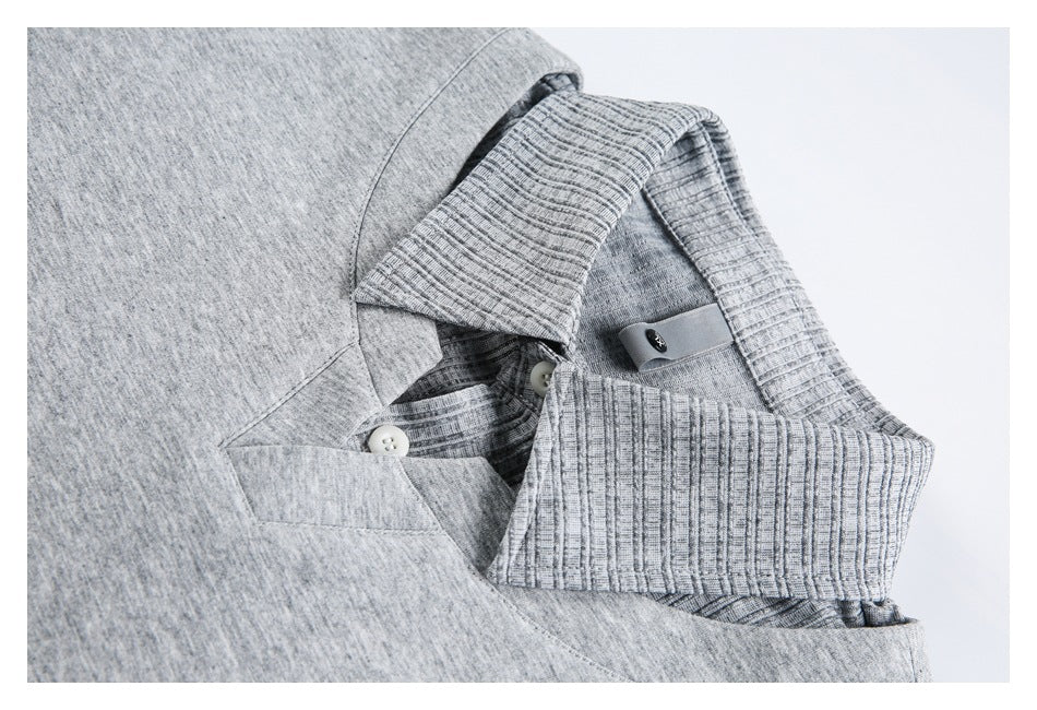 Close-up of a heather gray polo collar with ribbed trim and a button placket.