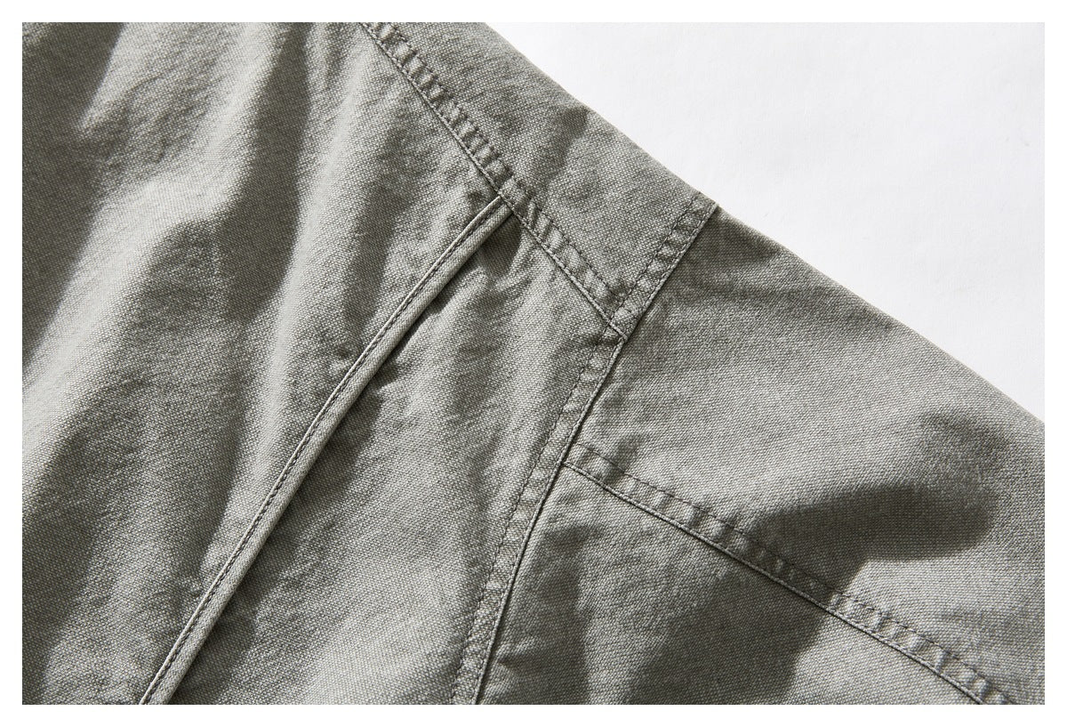 Close-up of a gray-green jacket's shoulder seam and sleeve stitching.