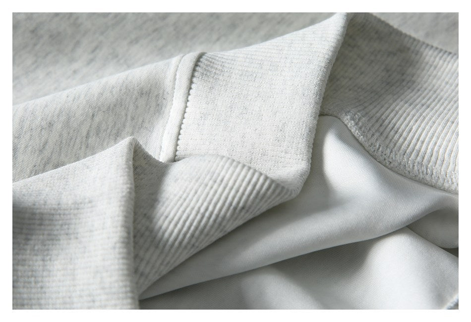 Close-up showing ribbed trim and the smooth inner side of a light gray heathered garment.